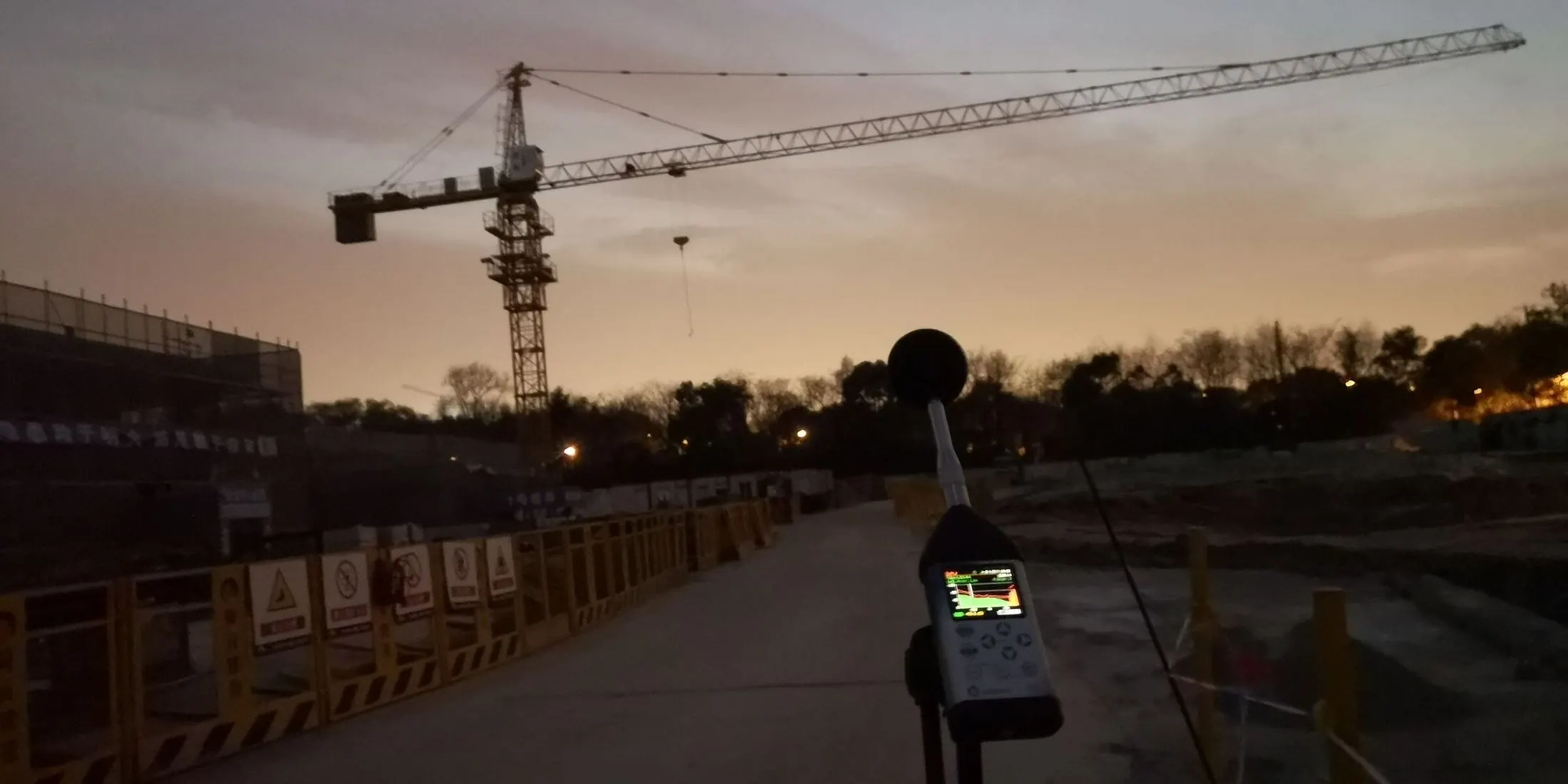 Environmental noise measurement at a construction site at dusk