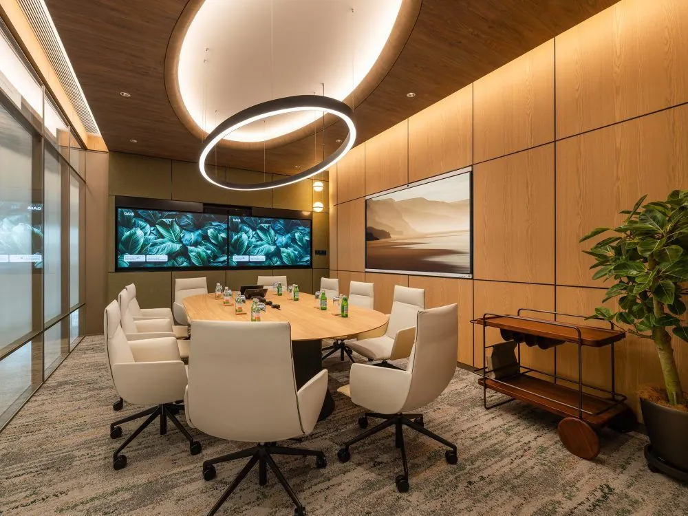 Meeting room with an oval table, wood paneling and wall displays