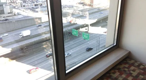 Guestroom overlooking interstate highway with single window assembly.