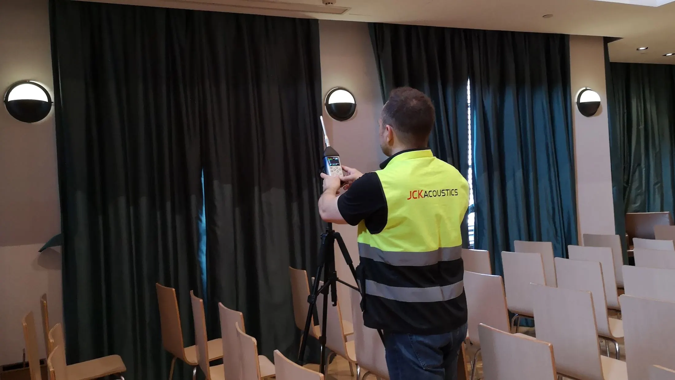 JCK Acoustics engineer taking room acoustic measurements in an auditorium