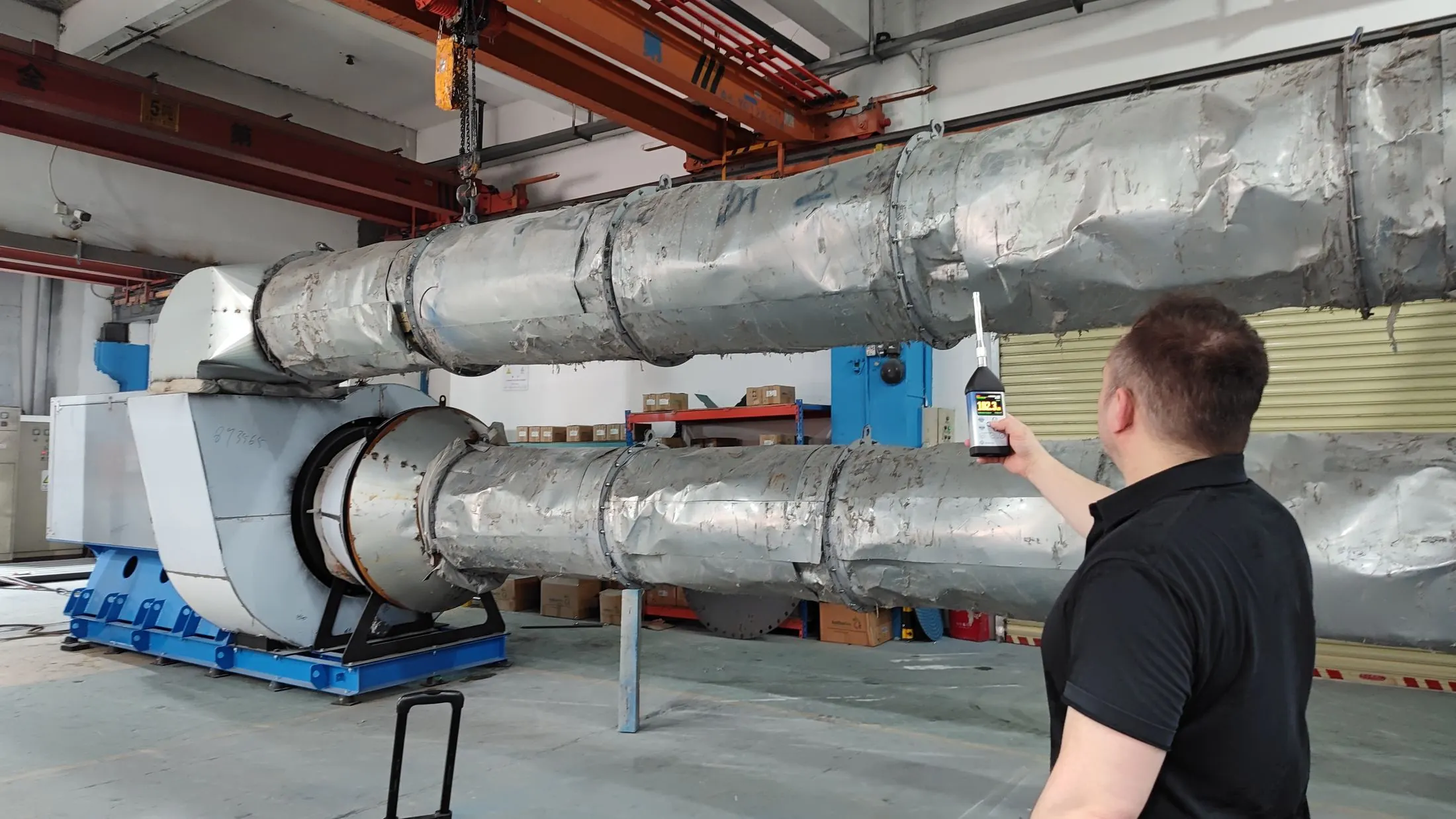 Engineer measuring noise from industrial fan equipment